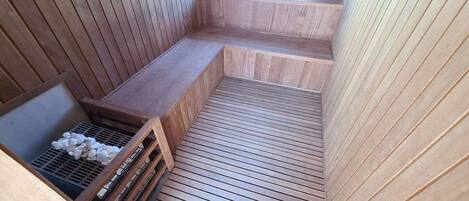 Una sauna de madera con bancos y suelo inclinado.