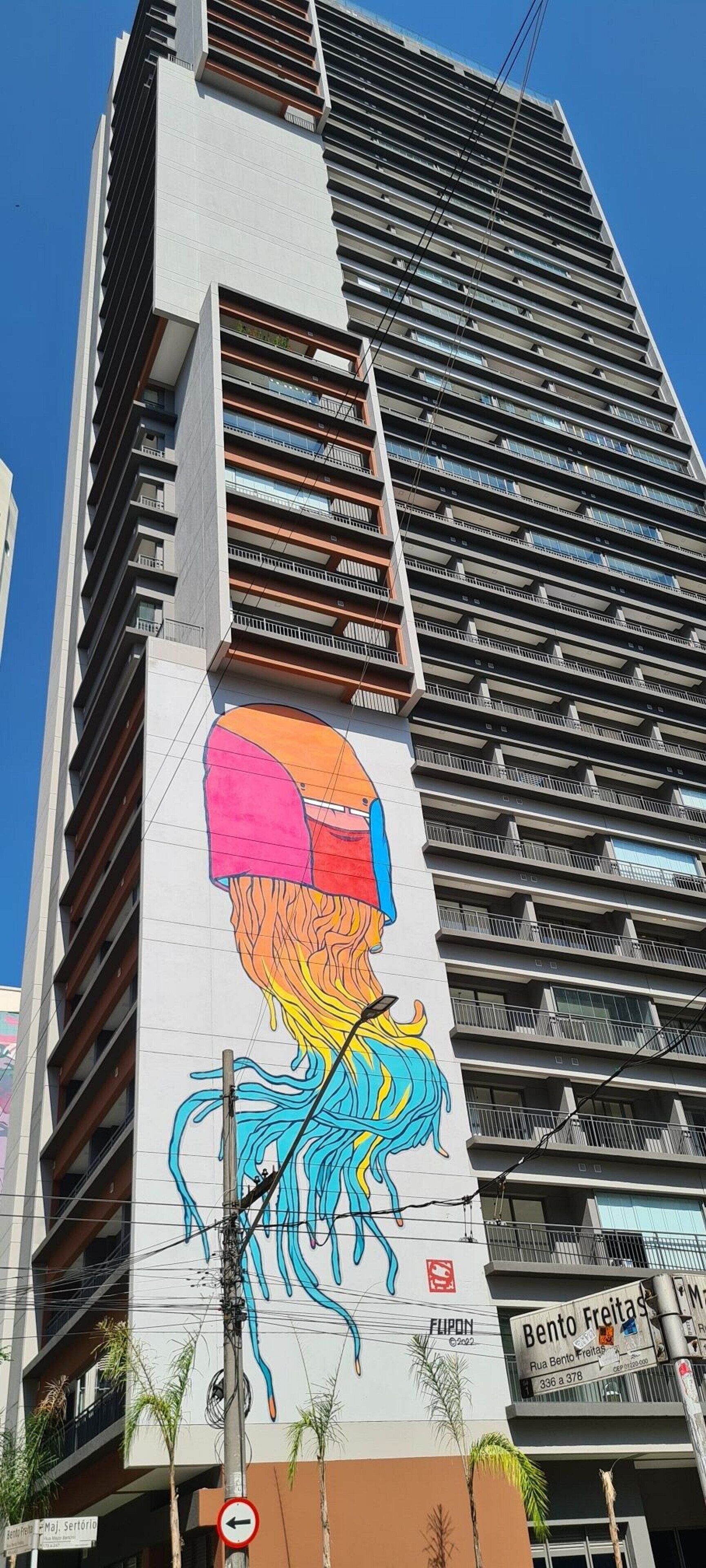 A high-rise building with a colorful mural on its side.