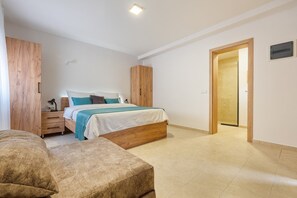 Quarto com cama, mesa de cabeceira e guarda-roupa de madeira.