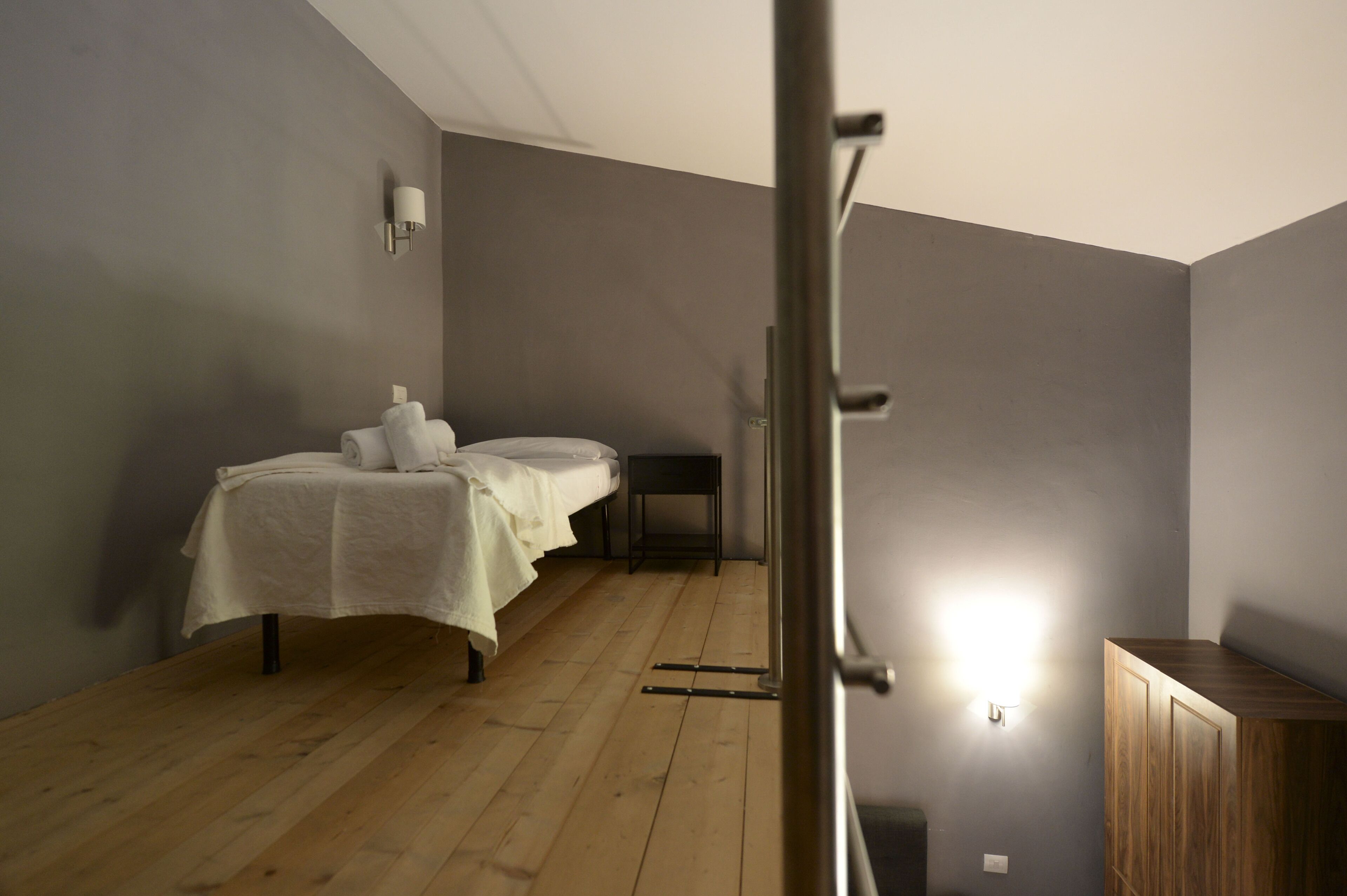 Een kamer met een bed, een klein tafeltje en een kast.