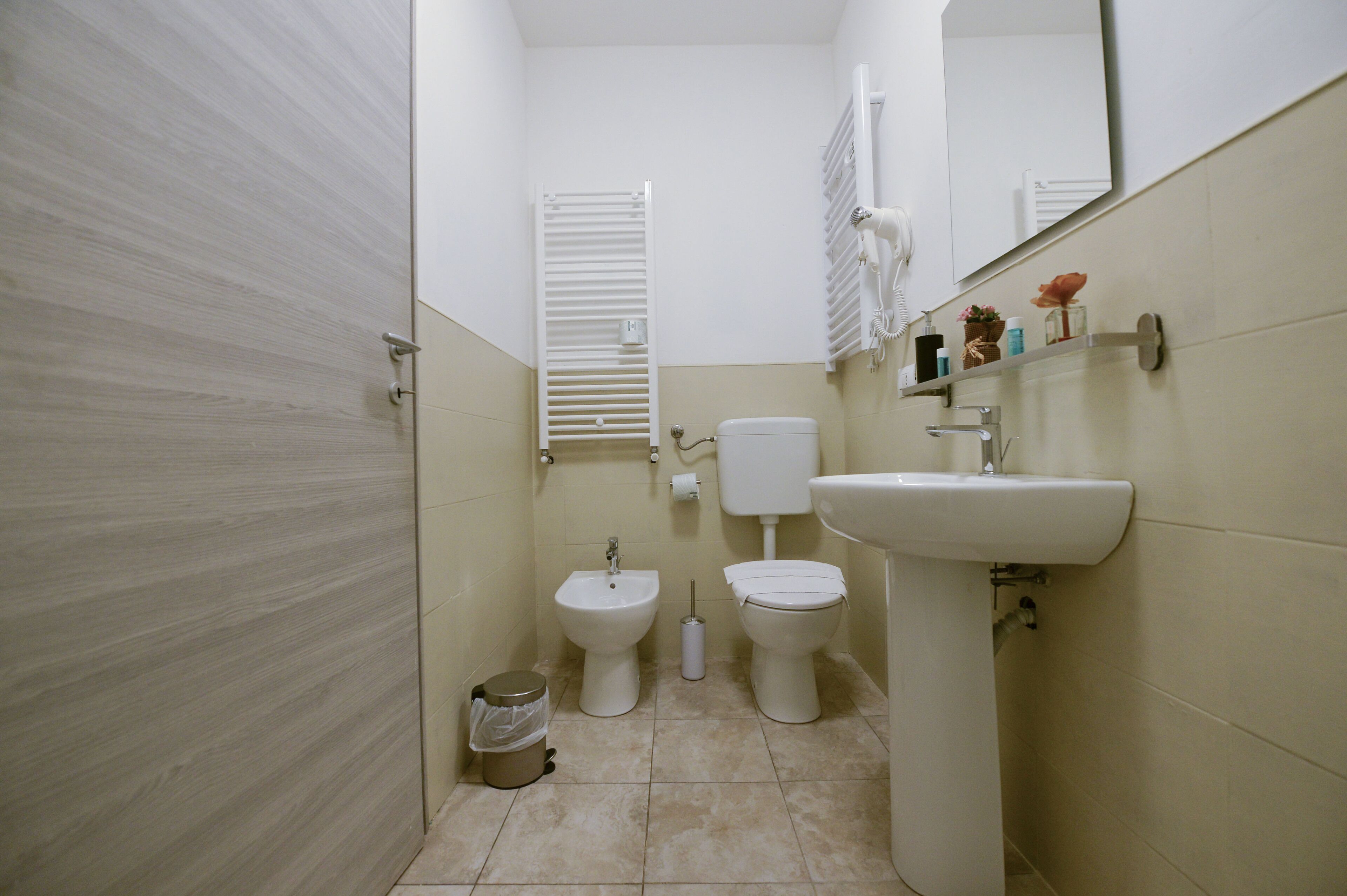 A small, clean bathroom with a toilet, bidet, and sink.
