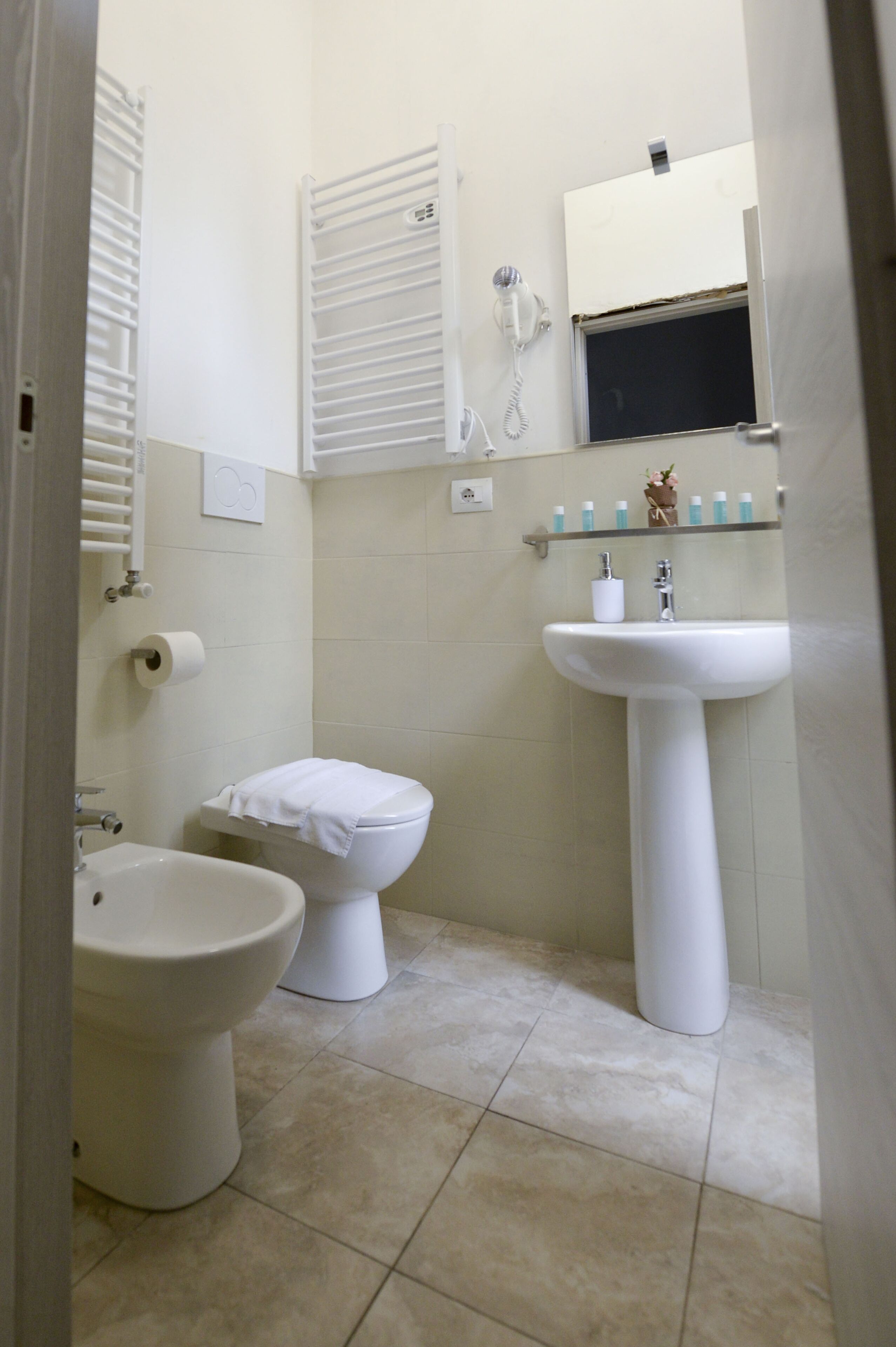 Une salle de bain équipée de toilettes, d’un bidet et d’un lavabo.