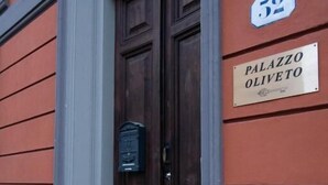 A building entrance with a dark wooden door and a sign reading "Palazzo Oliveto." - Palazzo Oliveto (Florence)