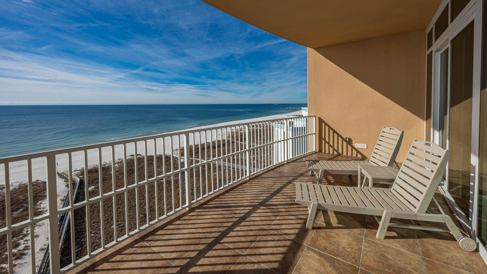 Un balcone con vista sull'oceano, arredato con due poltrone relax e un tavolino.