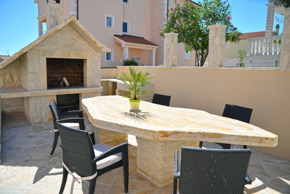 Un patio al aire libre con chimenea de piedra, una mesa y cuatro sillas.