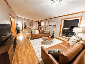 A living room with a sofa, coffee table, and TV. - Blue Ribbon Cabin (Farwell)