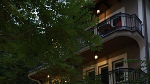 A multi-story building with balconies, a staircase, and a parked motorcycle.