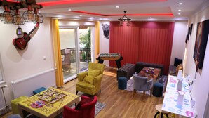 A cozy living room with a red sofa, a yellow armchair, and a table with a board game.