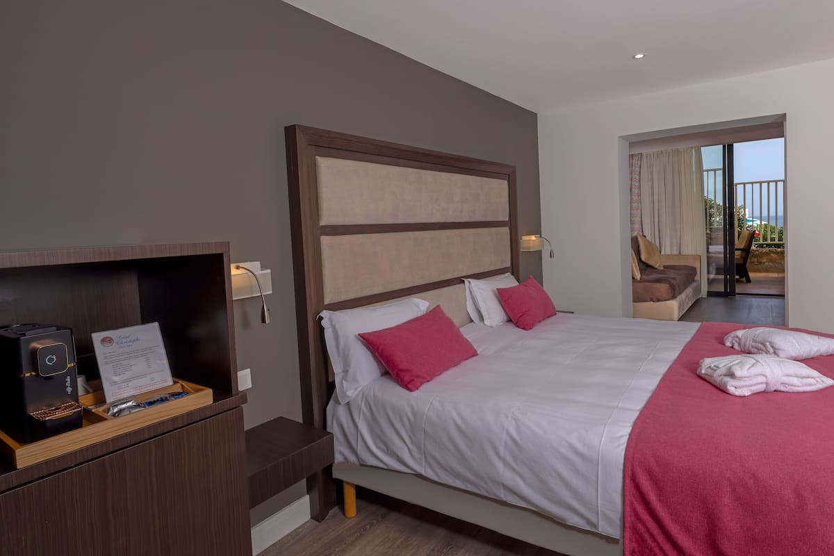Une chambre d’hôtel avec un lit, un bureau équipé d’un ordinateur et une vue sur l’extérieur.