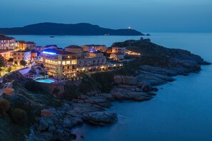 A coastal hotel with multiple buildings, a swimming pool, and a rocky shoreline. -  Saint Christophe (Calvi)