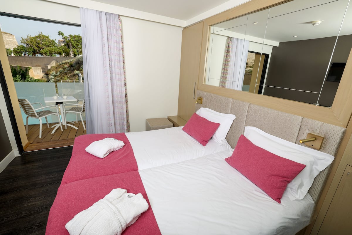 Une chambre d’hôtel avec un grand lit, une petite table et une chaise.