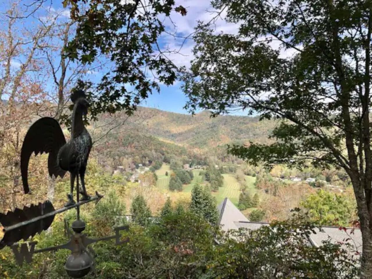 Une vue sur une vallée avec des maisons et une statue d’oiseau.