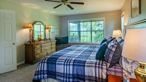 A bedroom with a bed, dresser, and window.