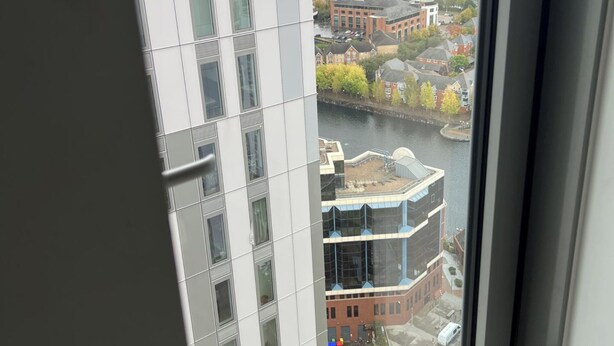 Un edificio de gran altura con vistas a un río y la zona urbana circundante.
