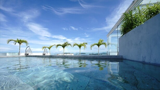 Una piscina cristalina con palmeras y cielo despejado.