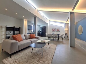 A modern living room with a sofa, coffee table, and dining area. - Lesplanade by Wynwood House (Panama City)
