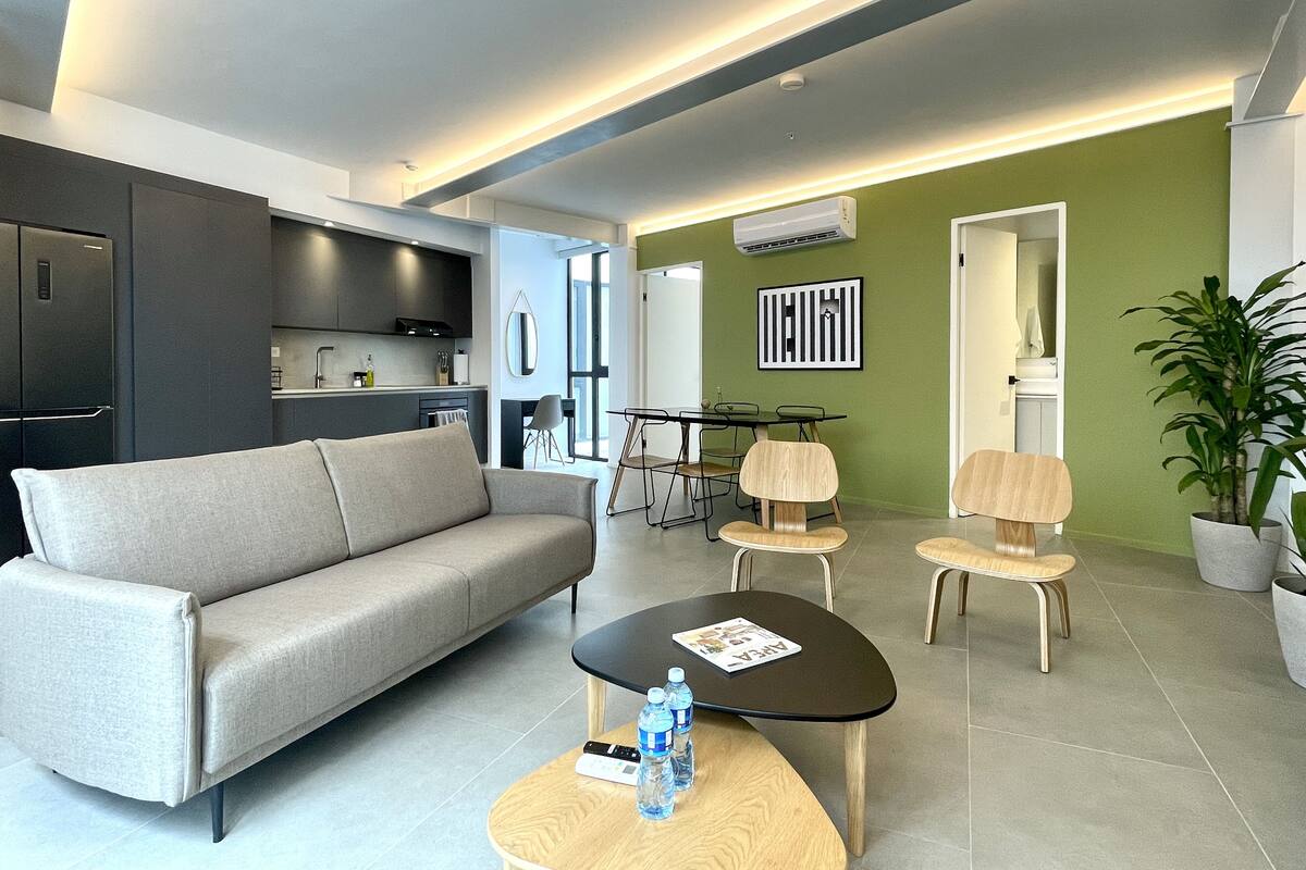 Ein modernes Wohnzimmer mit einer Couch, einem Couchtisch und einem Essbereich mit Stühlen.