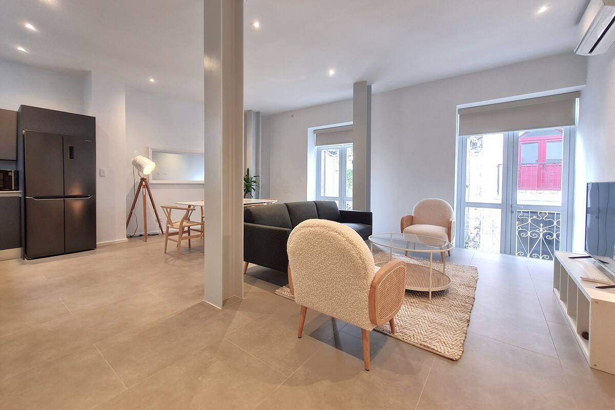 Eine moderne Wohnung mit Küche, Wohnbereich und Balkon.