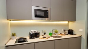 Une cuisine moderne équipée d’un four à micro-ondes, d’un grille-pain et d’une bouilloire encastrés.