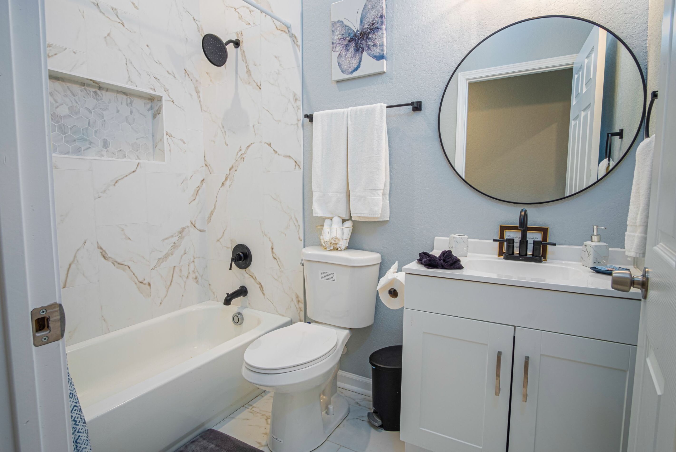 A bathroom with a bathtub, toilet, and vanity.