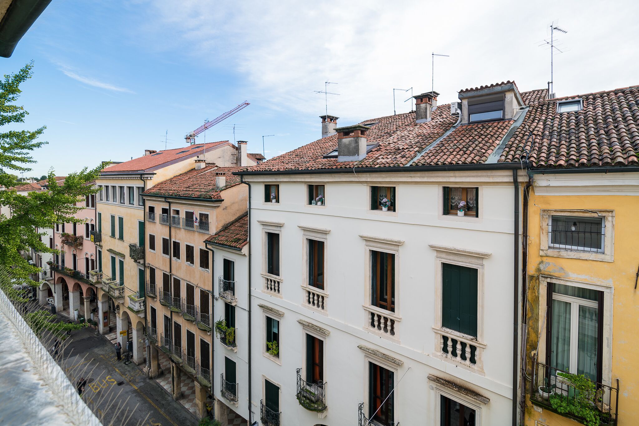 Une rangée de bâtiments européens traditionnels à l’architecture uniforme, dotés de balcons et se dressant sous un ciel dégagé.