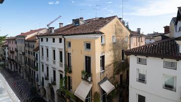 A row of buildings with balconies, some with plants, and a clear sky.