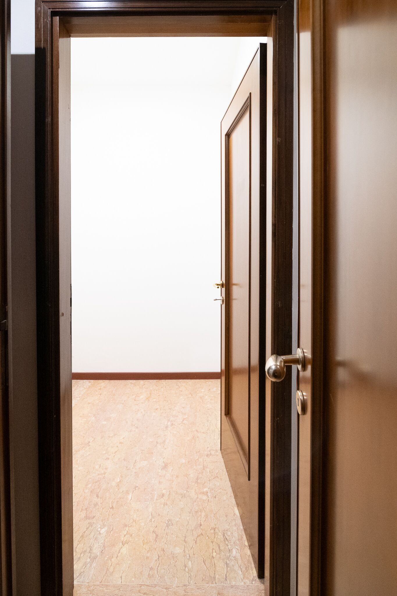 A doorway leading to a room with a tiled floor and a plain wall.