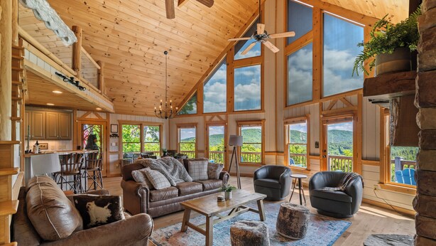 A spacious living area with a high ceiling, large windows, and a cozy seating arrangement. - Unreal MTN Views • Secluded • Soak Dine Unwind (Epworth)