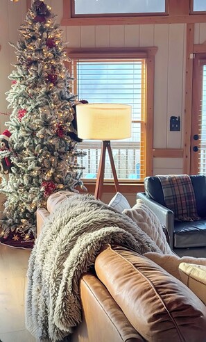 Una sala de estar acogedora con un árbol de Navidad, una lámpara y un sofá.