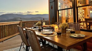 A dining table set on a wooden deck with a scenic mountain view. - Unreal MTN Views • Secluded • Soak Dine Unwind (Epworth)