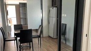 Una cocina moderna con comedor, suelo de madera y un espejo grande en la pared.
