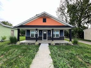 A two-story house with a front porch, a driveway, and a mailbox.