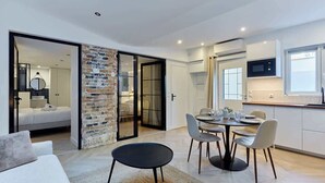 A modern apartment with a dining area, kitchen, and a bedroom with a sliding glass door. - Superb apartment Arc de Triomphe (Paris)