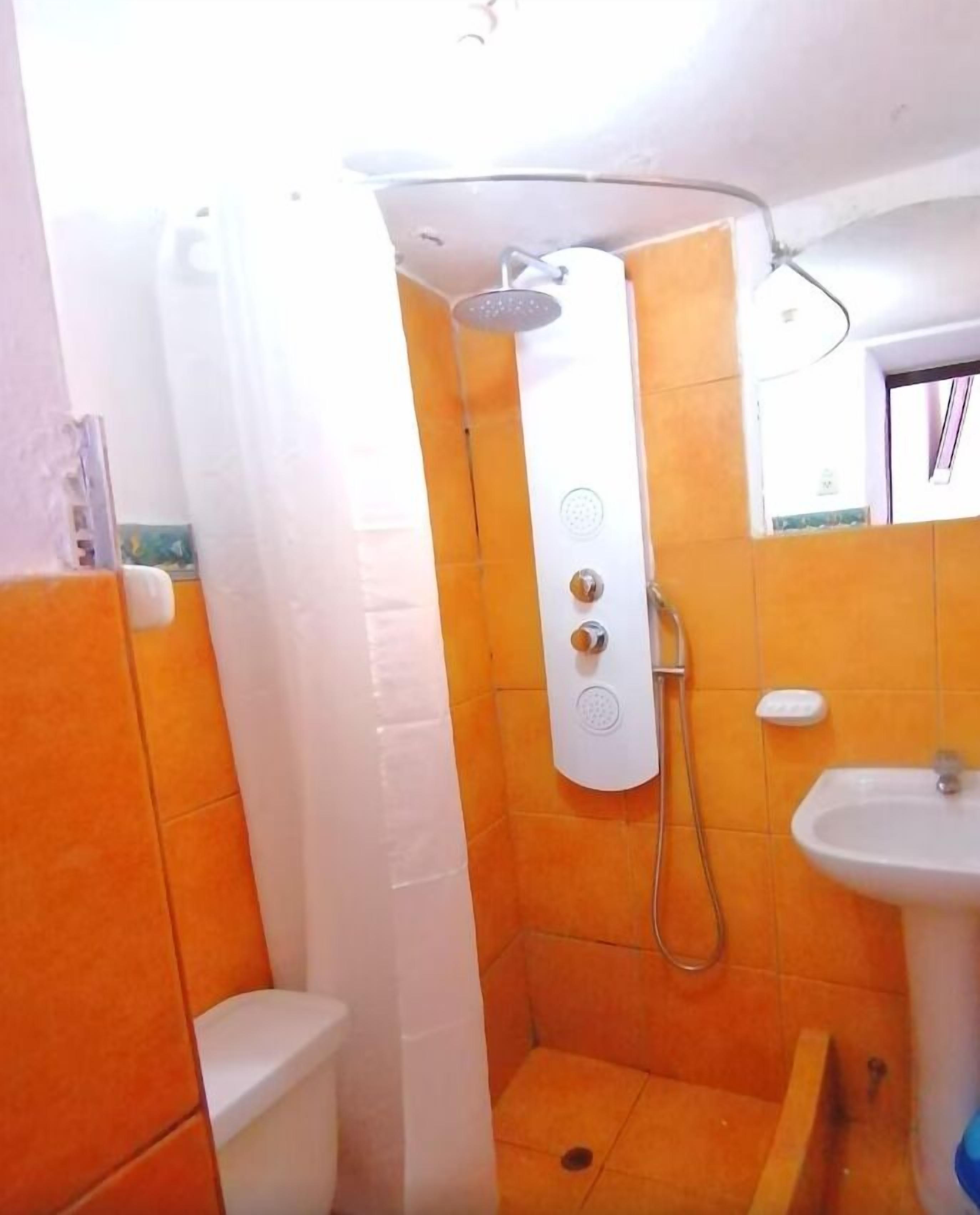 Ein Badezimmer mit Dusche, Toilette und Waschbecken.