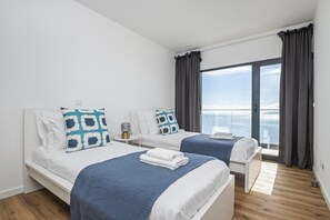 A hotel room with two beds, a large window with curtains, and a view of the sky. - Casa Jos Ant nio A by Homie (Santa Cruz)