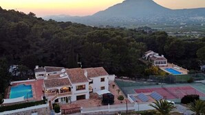 A large house with a swimming pool, tennis court, and a view of a mountain. - 12 Persoons luxe villa in Javea. Heated pool! (Jávea)