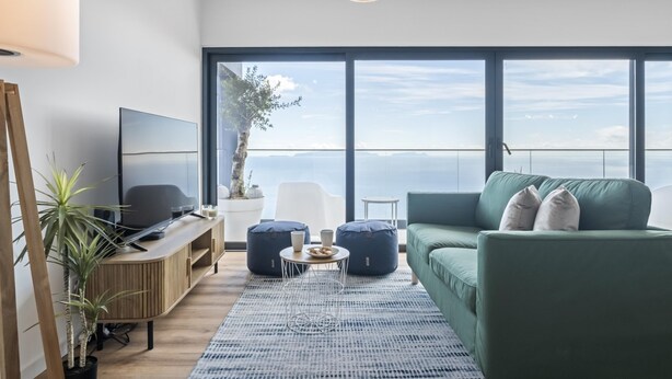 A modern living room with a large window, a flat-screen TV, a green sofa, and a coffee table. - Casa Jos Ant nio B by Homie (Santa Cruz)