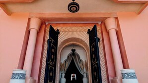 A building entrance with a large archway, two large potted plants, and a set of stairs leading up to the entrance. - Riad Las Palmeras Guest House, Marrakech (Marrakech)