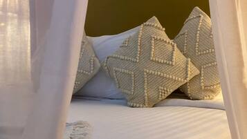 A bed with white bedding and decorative pillows.