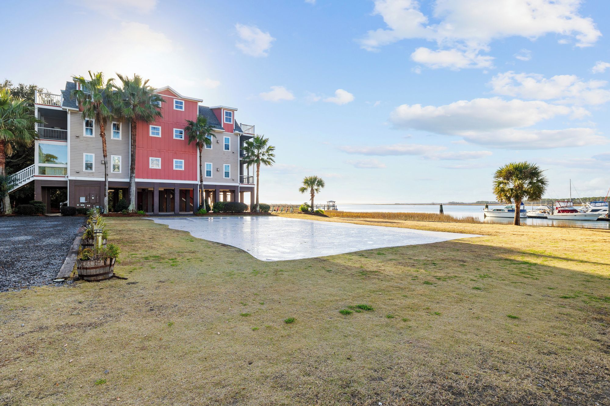 A beachfront property with a large patio area, a pool, and a view of the ocean.