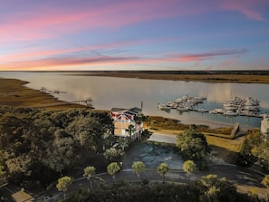 Una proprietà sul lungomare con un molo, un porto turistico e una casa grande con un balcone vista mare.