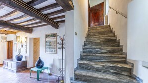 A staircase with stone steps leading to a wooden door. - Casale Il Farro (Camaiore)