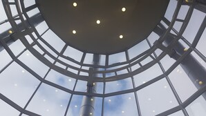 Een rond glazen dak met meerdere lichtarmaturen.