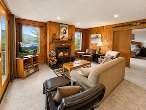 A cozy living room with a fireplace, a sofa, a coffee table, and a television. - Slope Side Amazing Location (Snowshoe)
