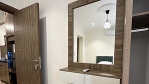 A hotel room with a wooden wardrobe, a mirror above a white console table, and a green bench. - 3 Antica jabalal-lwebdeh (Amman)
