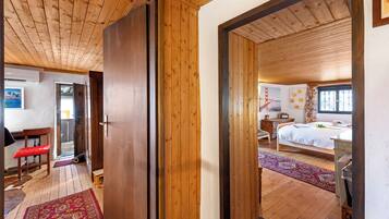 Una habitación con suelo de madera, una cama, un escritorio y una silla.