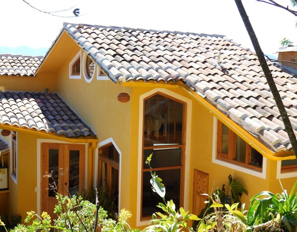 A yellow building with a tiled roof and multiple windows. - La Casa de las Aves - Maison D'architecte - Romantique & Cosy + Jardin Privé (San Cristóbal de las Casas)