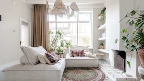 Ein gemütliches Wohnzimmer mit einem Ecksofa, einem gemusterten Teppich und einem Kamin.