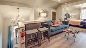 Un loft spacieux comprenant un coin repas, un canapé et un lit.