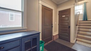 Un couloir avec un bureau, deux portes et un escalier.